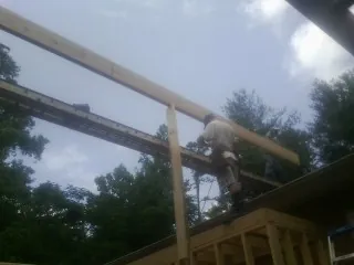 Carpenter setting a ridge beam over a new addition frame — Ice Dam Removal by Roofing Brothers in West Alton