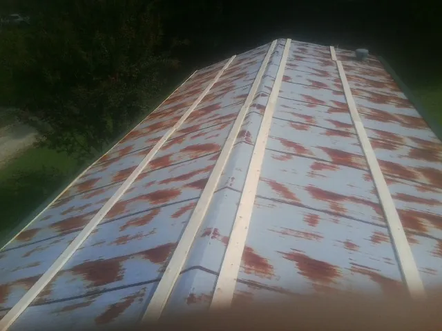 Rusted metal roof panels with new wood purlins before replacement — Storm Damage Roof Repair in West Alton by Roofing Brothers