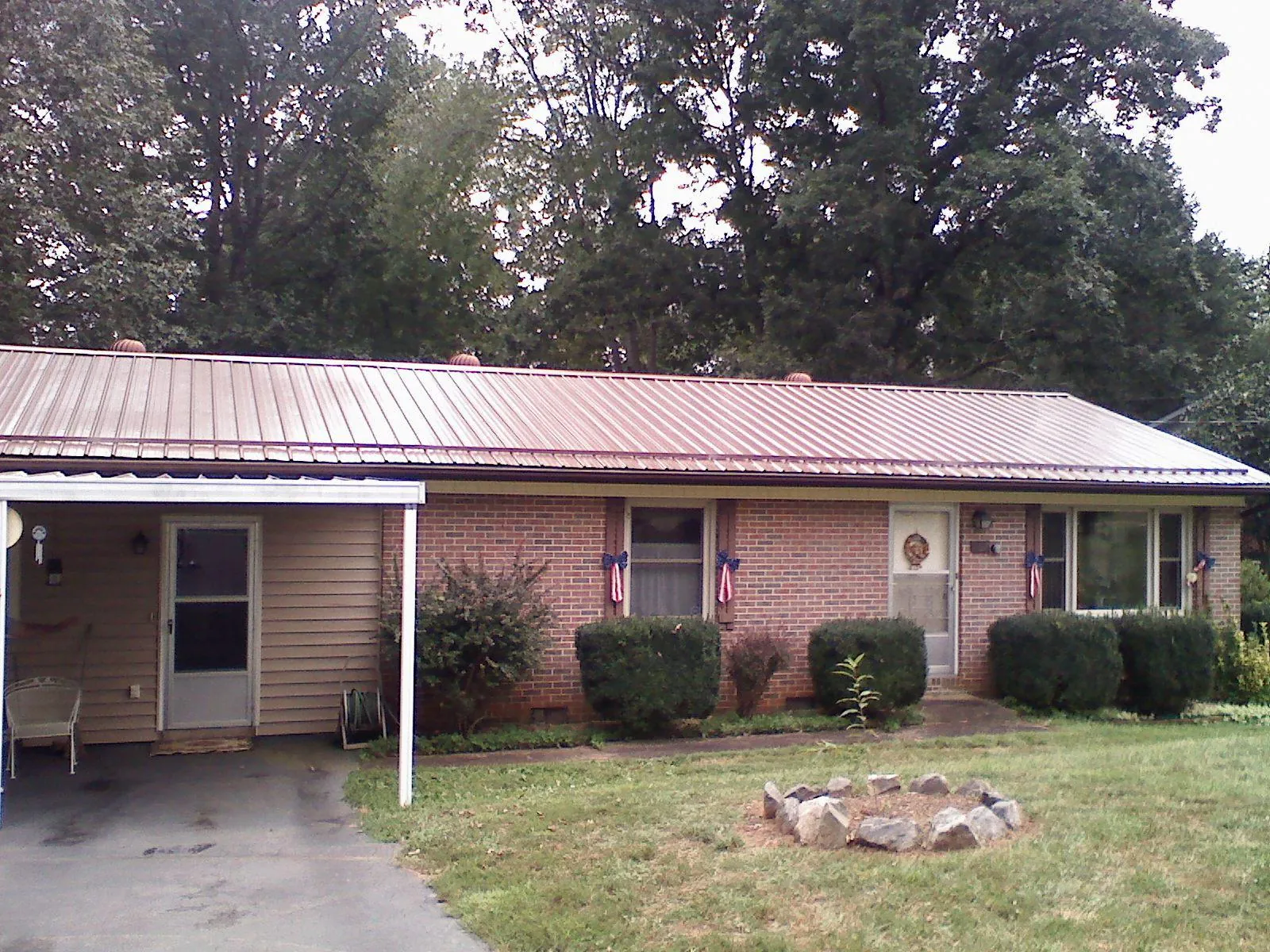 Bronze metal roof and carport on a brick ranch home — Roof Repair work by our crew in West Alton