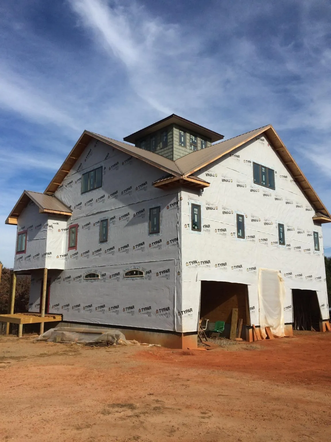 New two story house under construction with a cupola and gabled roofs in West Alton